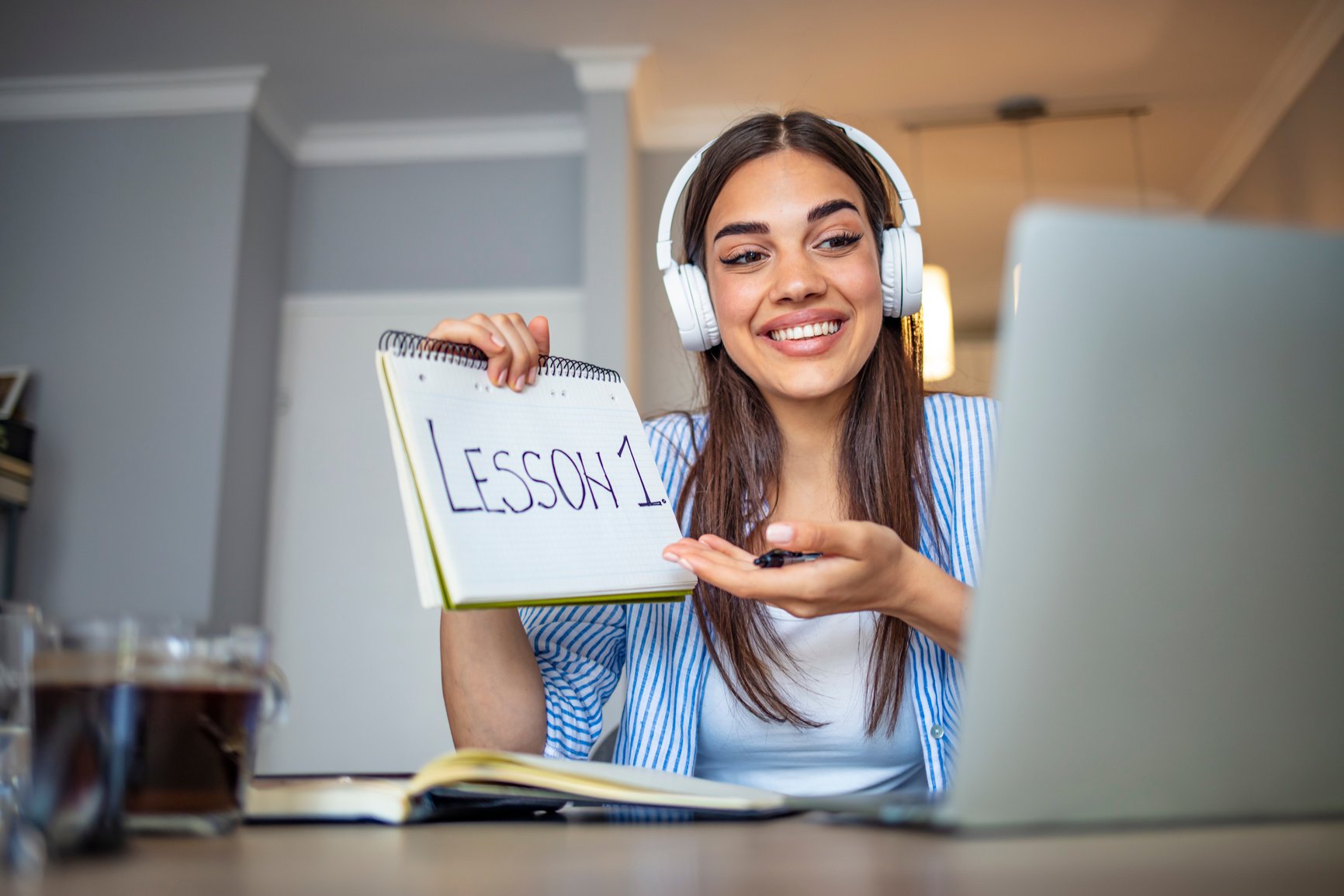 Millennial pleasant professional female tutor giving online language class.